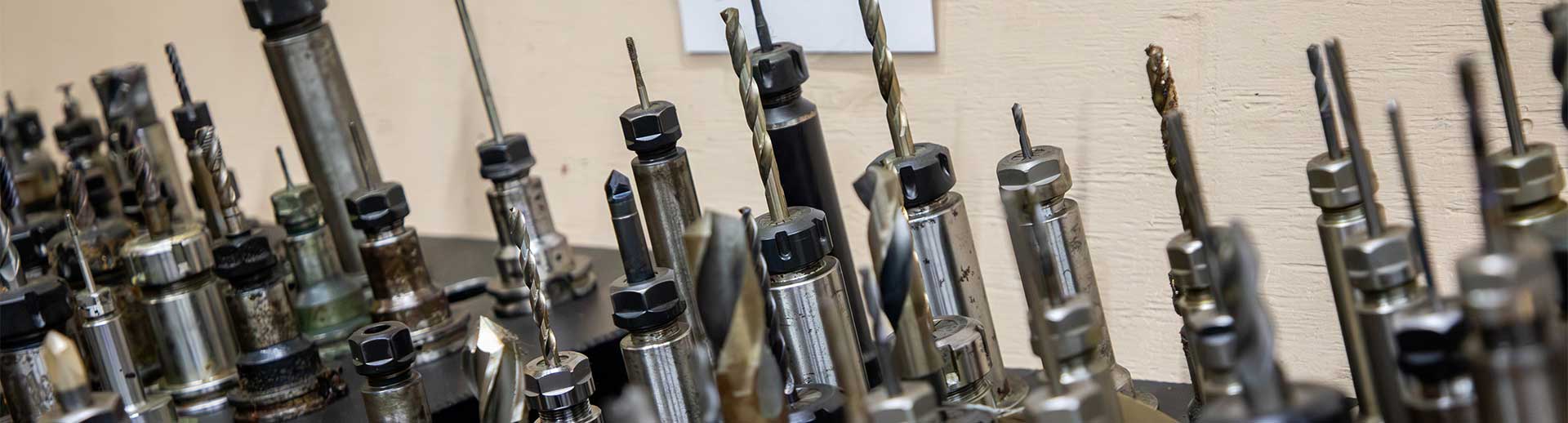 Rows of CNC tool holders and drill bits